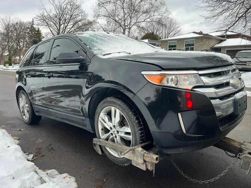 Black SUV loaded onto a tow truck for junk and scrap car towing in Milton, Ontario